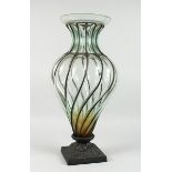A LARGE GLASS VASE with metal mounts on a square base, 2 ft. 2 in. high.