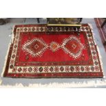 A small Persian red ground rug.