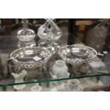 A pair of silver twin handled bonbon dishes with pierced sides.