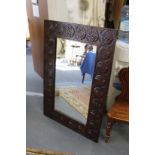 A large mirror with carved wood frame.