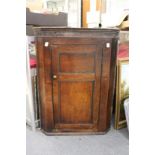 A George III oak hanging corner cupboard.