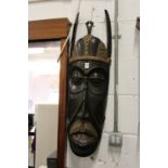 A large carved wood wall mask.