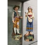 A pair of continental maiolica glazed pottery figures of musicians.