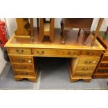 A reproduction yew wood pedestal desk.
