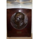 A French bronze circular relief carved plaque of a gentleman mounted on a mahogany frame.