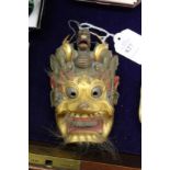 A small Chinese carved and gilded mask.