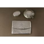 An engraved silver calling card case and two pill boxes.