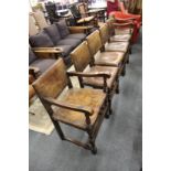 A set of six oak and studded leather dining chairs, two with arms.
