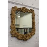 A wall mirror with a decoratively carved hardwood frame.