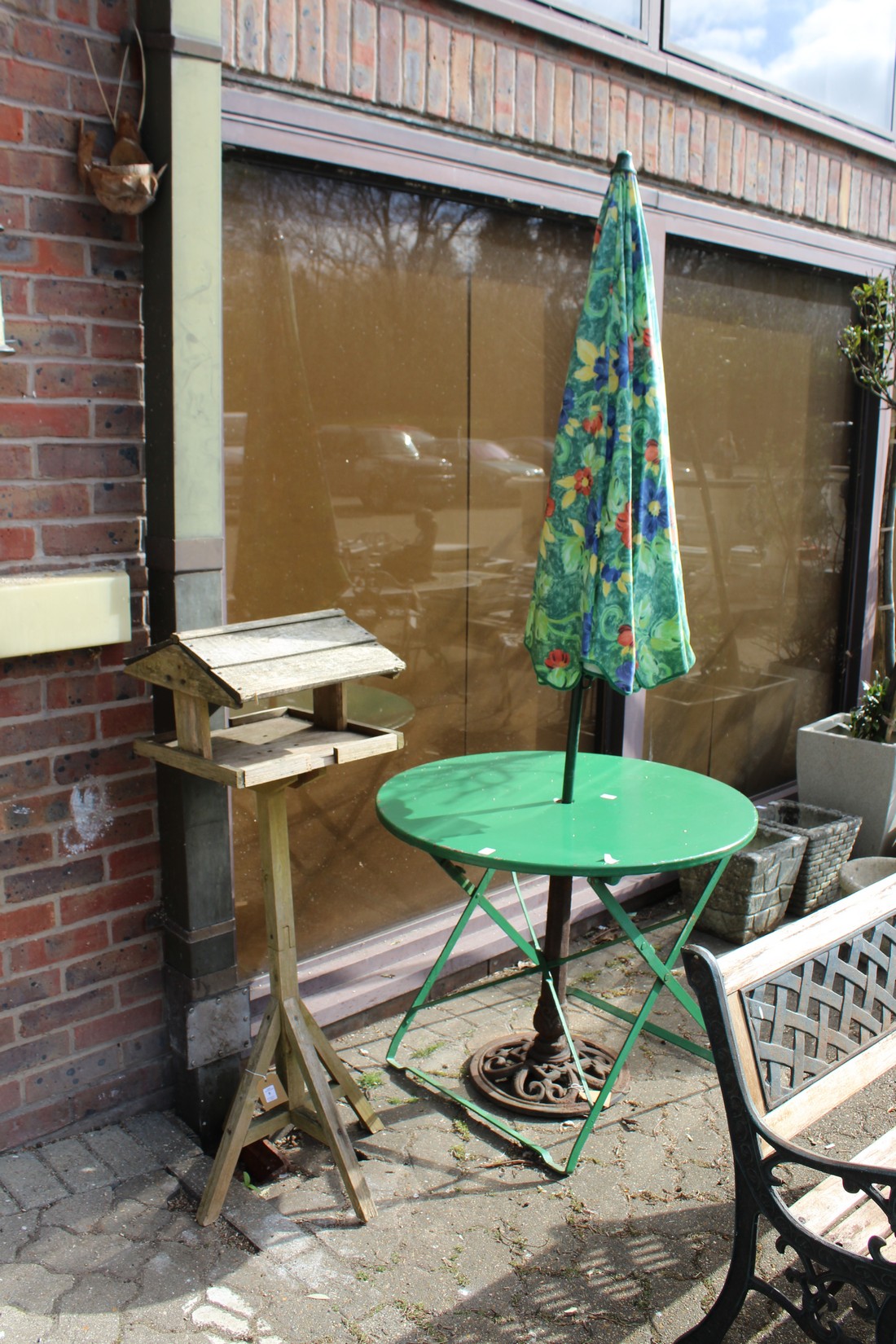 A bird table, a folding table and parasol.