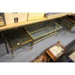 A brass and glass two tier coffee table and a pair of matching lamp tables.