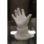 A small bisque porcelain model of a baby's hand.