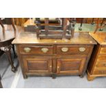 An 18th century small oak dresser with two drawers and two cupboard doors.