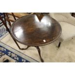 A George III mahogany tilt top tripod table with carved decoration.