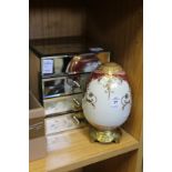 A porcelain egg and a mirrored jewellery chest.