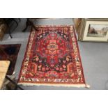A red ground Persian design small rug.