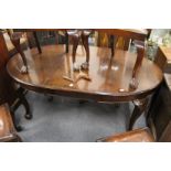 A mahogany extending dining table with one extra leaf on carved cabriole legs with claw and ball