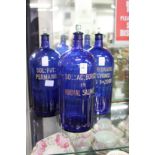 Three large blue glass poison bottles.