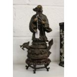 A Chinese bronze standing Buddha on a hardwood stand.
