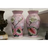 A pair of floral painted pink vases.