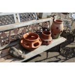 A garden ornament modelled as a cat and three terracotta strawberry pots.