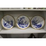 A set of three blue and gilt decorated cabinet plates depicting imps and fairies.