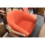 A modern red upholstered tub armchair.