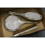 A silver three piece dressing table set.