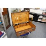 A leather travelling case fitted with silver topped jars and other items.