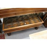 An eastern hardwood and glass topped coffee table converted from a door with wrought iron fittings.