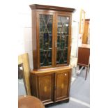 An Edwardian inlaid mahogany standing corner display cabinet with a pair of glazed doors above a