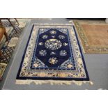 A Chinese rug, blue ground with floral and insect decoration.