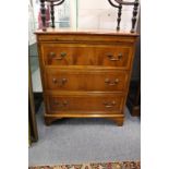 A reproduction yew wood three drawer chest with brushing slide.