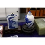 Two Chinese blue and white snuff bottles with associated stands.