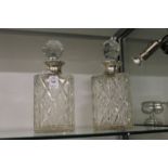 A pair of cut glass and silver mounted whisky decanters.