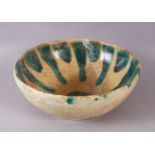 A 12TH CENTURY ABBASID POTTERY BOWL, with a turquoise drip glaze, 23cm