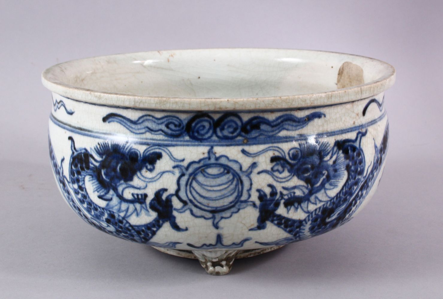 A CHINESE BLUE & WHITE PORCELAIN DRAGON TRIPOD POT / PLANTER, the body with a crackle glaze and