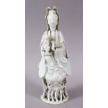 A CHINESE BLANC DE CHINE PORCELAIN FIGURE OF GUANYIN & CHILD, stood upon rising lotus, 22cm.