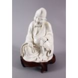 A CHINESE BLANC DE CHINE PORCELAIN FIGURE OF A SEATED SCHOLAR, with a hardwood carved base, (AF)