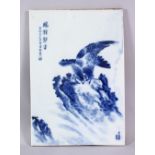 A CHINESE BLUE & WHITE PORCELAIN HAWK TILE / PANEL, depicting a hawk landed upon rocky outcrops