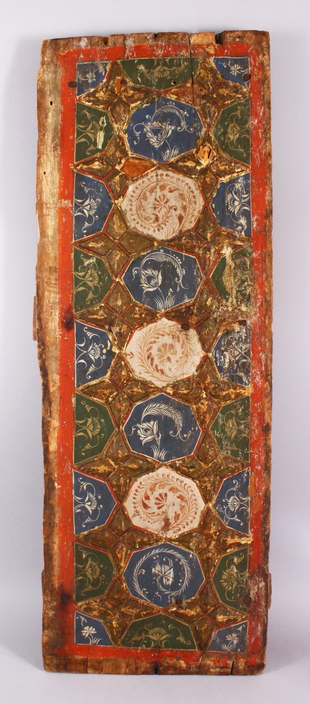 A LARGE 17TH / 18TH CENTURY PERSIAN WOODEN PANEL, with moulded star decoration with painted flora,