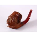 A CARVED WOOD SMOKING PIPE, the bowl in the form of an African male, the mouthpiece made of cherry