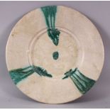 A 12TH CENTURY ABBASID POTTERY PLATE, with green drip decoration, 34cm.
