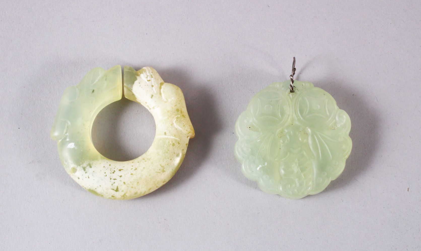TWO CHINESE CARVED JADE BUTTERFLY & DRAGON BI DISK PENDANTS, one pale almost translucent jade carved
