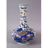 A CHINESE IRON RED & BLUE PORCELAIN BOTTLE STYLE VASE, decorated with lion dogs and ball amongst