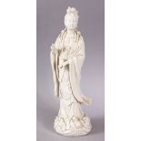 A CHINESE BLANC DE CHINE PORCELAIN FIGURE OF GUANYIN, stood upon a wave form style base, 29cm high.