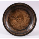 A 19TH CENTURY ISLAMIC CALLIGRAPHIC DISH, carved with calligraphy and floral panels, 23cm