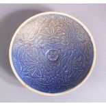 A CHINESE MOULDED BLUE GLAZED DISH, with fish and floral decoration, 13cm