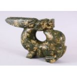 A CHINESE CARVED HARDSTONE FIGURE OF A DRAGON, in archaic form, looking behind, 26cm wide.