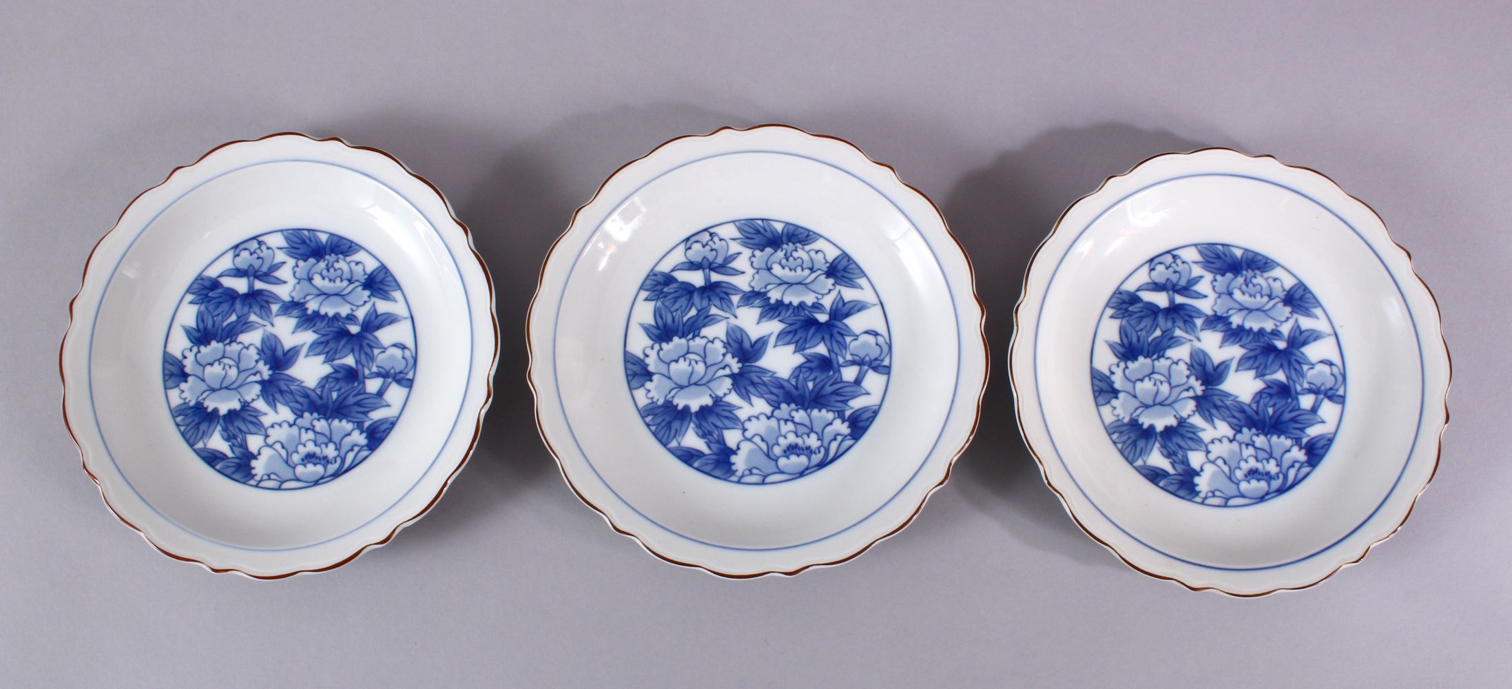 THREE JAPANESE BLUE & WHITE FUKAGAWA PORCELAIN PLATES, each with central floral underglaze blue